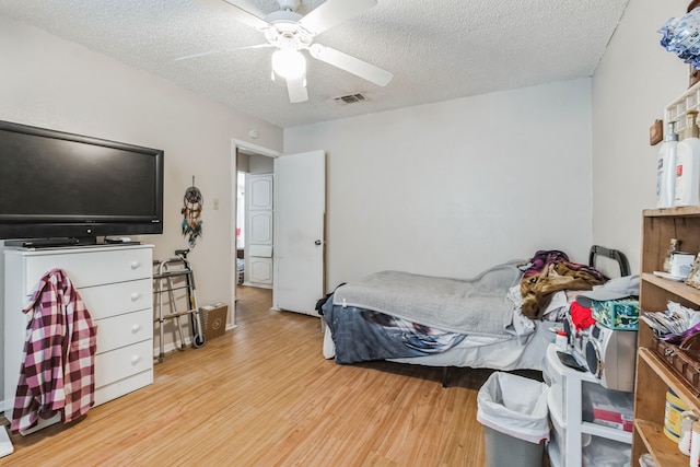 bedroom featuring a textured ceiling, ceiling fan, and light hardwood / wood-style floors