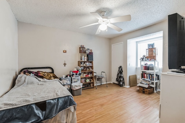 bedroom with light hardwood / wood-style floors, a textured ceiling, and ceiling fan