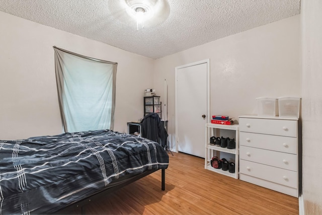 bedroom featuring a textured ceiling and wood finished floors