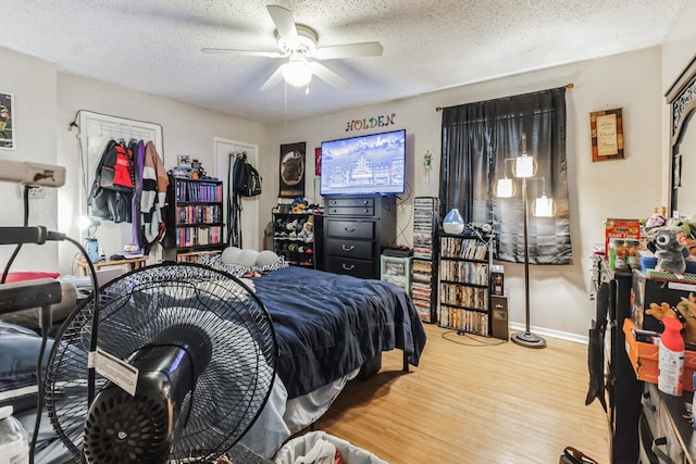 bedroom featuring ceiling fan, light hardwood / wood-style floors, and a textured ceiling