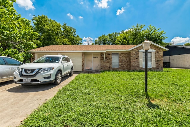 ranch-style home featuring a garage and a front lawn