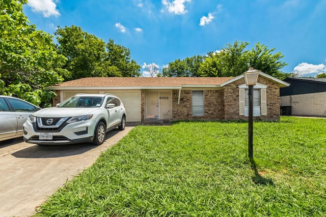 single story home with concrete driveway, brick siding, an attached garage, and a front lawn