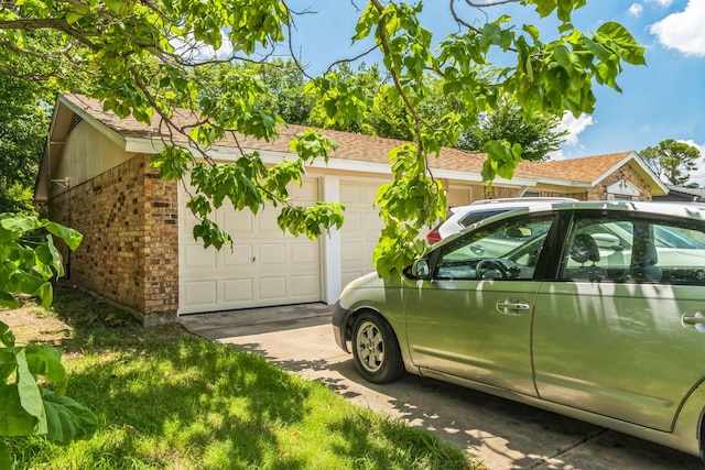 view of side of property featuring a garage and brick siding