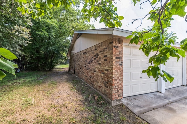 view of home's exterior with concrete driveway and brick siding