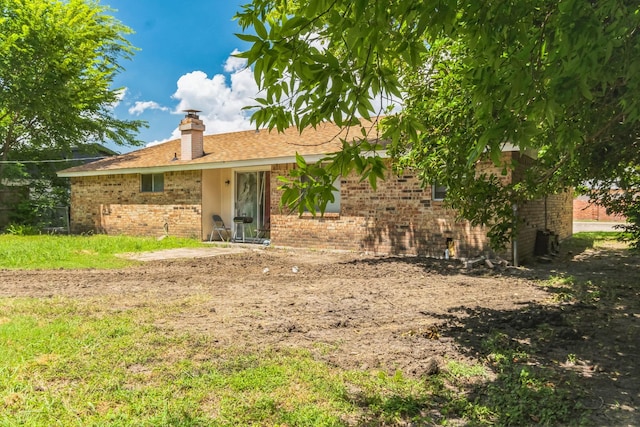 view of front of property with brick siding and a chimney