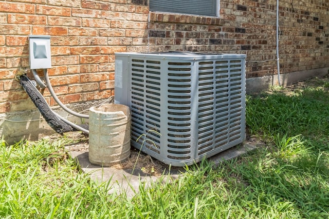 exterior details featuring brick siding and central air condition unit