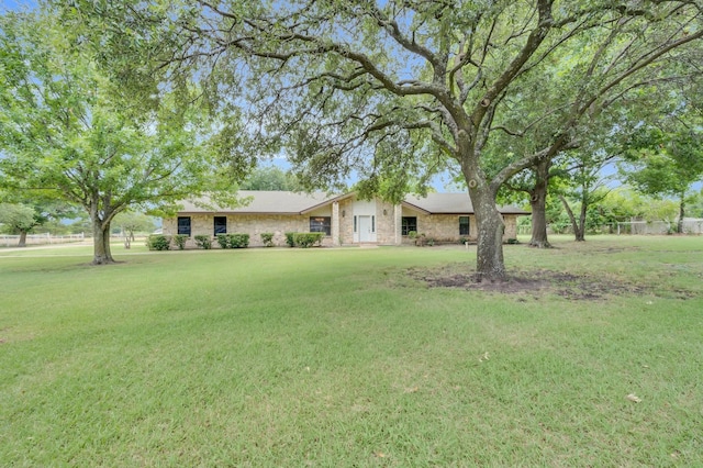 single story home featuring stone siding and a front yard