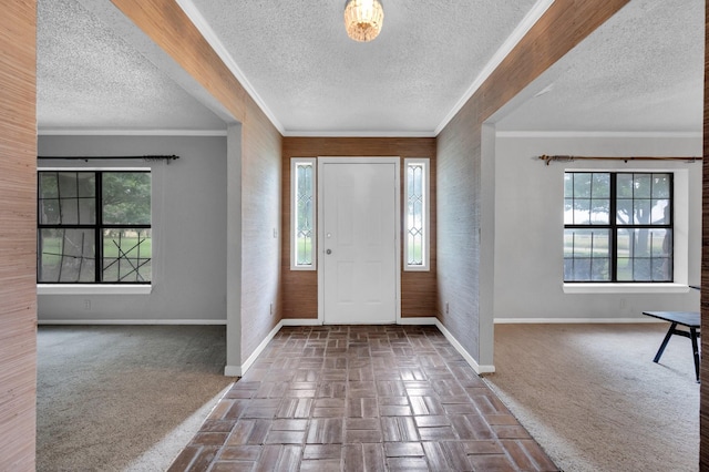 entrance foyer with dark colored carpet, a healthy amount of sunlight, and baseboards