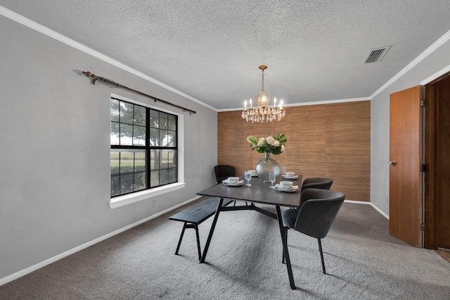 carpeted dining space featuring a notable chandelier, visible vents, ornamental molding, a textured ceiling, and baseboards