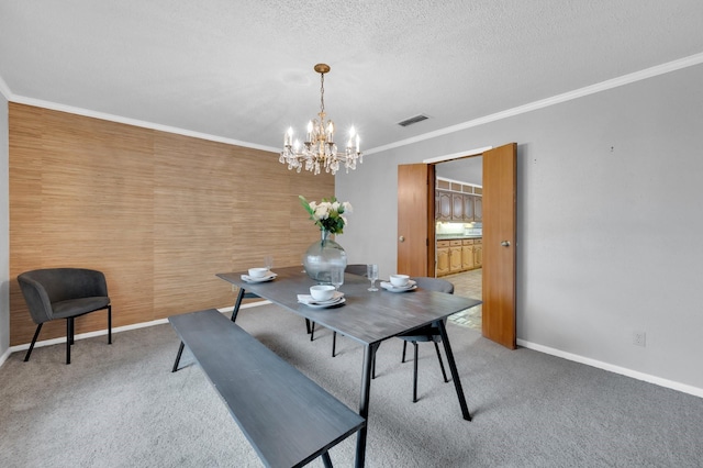 dining room with carpet floors, crown molding, visible vents, a textured ceiling, and baseboards