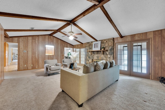 living room featuring light carpet, vaulted ceiling with beams, a textured ceiling, and french doors