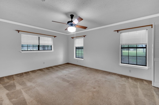 empty room with a ceiling fan, light carpet, crown molding, and a textured ceiling