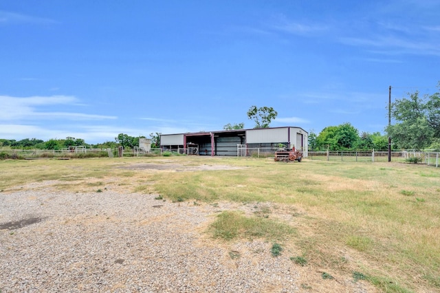 view of yard with an outbuilding, a pole building, a rural view, and fence