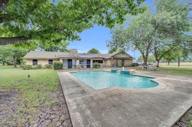 view of pool featuring a pool with connected hot tub, a patio, and a lawn