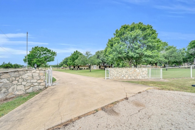 view of street featuring aphalt driveway, a gated entry, and a gate