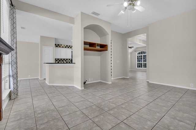 unfurnished living room with light tile patterned floors and ceiling fan