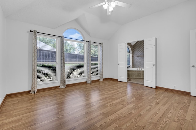 unfurnished bedroom with vaulted ceiling, ensuite bathroom, ceiling fan, and hardwood / wood-style floors