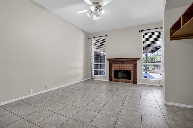 unfurnished living room with lofted ceiling, a tile fireplace, light tile patterned floors, and ceiling fan