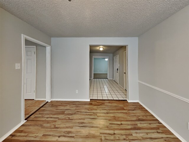 spare room with light hardwood / wood-style floors and a textured ceiling