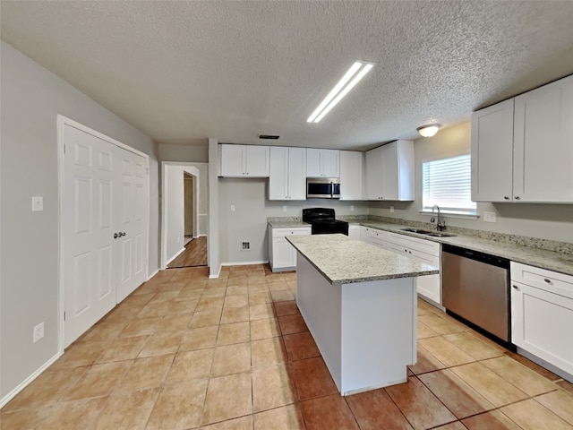 kitchen with appliances with stainless steel finishes, light tile patterned flooring, and sink