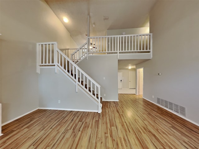 interior space featuring a high ceiling and wood-type flooring