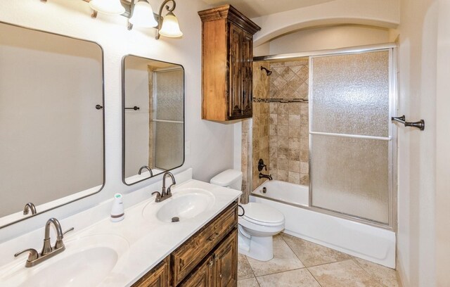 full bathroom featuring tile patterned flooring, double vanity, toilet, and enclosed tub / shower combo