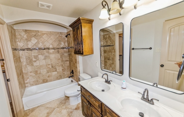 full bathroom with tiled shower / bath combo, toilet, tile patterned flooring, and dual bowl vanity