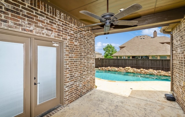 view of swimming pool featuring a patio and ceiling fan