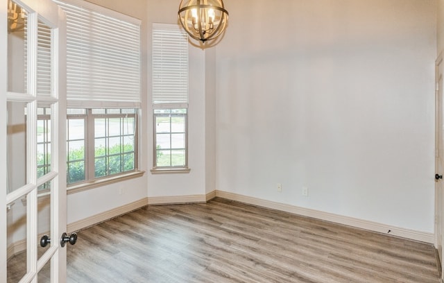 unfurnished room featuring light hardwood / wood-style floors and a chandelier