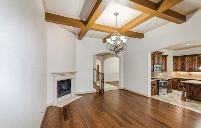 living room featuring light tile patterned floors, an inviting chandelier, beamed ceiling, coffered ceiling, and a premium fireplace