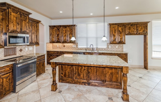 kitchen featuring tasteful backsplash, a kitchen island, stainless steel appliances, light stone countertops, and plenty of natural light