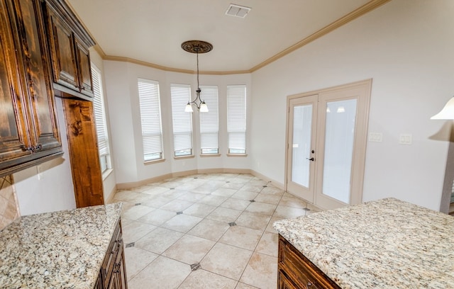 tiled dining space with crown molding and french doors