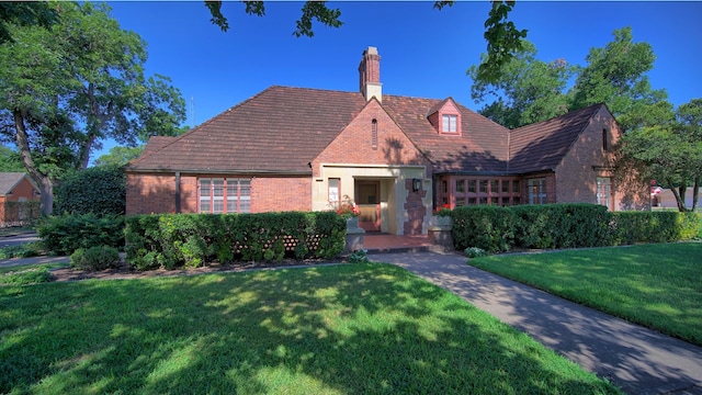 english style home with a front yard