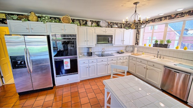 kitchen with white cabinets, black appliances, decorative backsplash, tile countertops, and sink