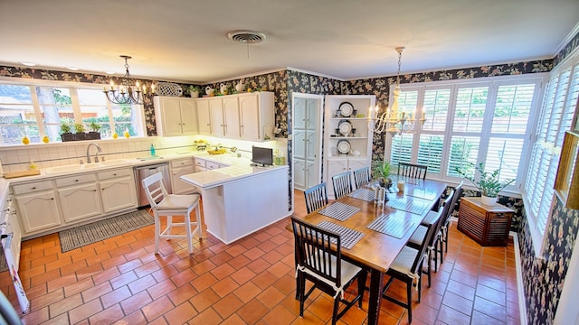 dining space featuring a notable chandelier, sink, and a wealth of natural light