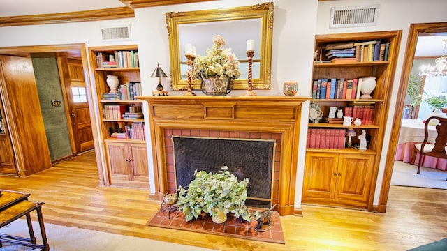 living room with light hardwood / wood-style floors, a notable chandelier, and crown molding