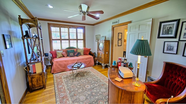 living room with light wood-type flooring, ceiling fan, and ornamental molding