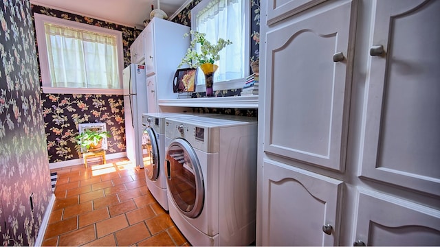 laundry room featuring independent washer and dryer, tile patterned floors, and cabinets