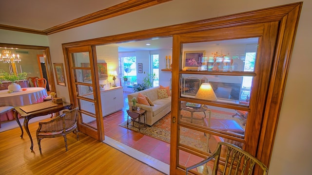 living room with ornamental molding, a notable chandelier, and light hardwood / wood-style floors