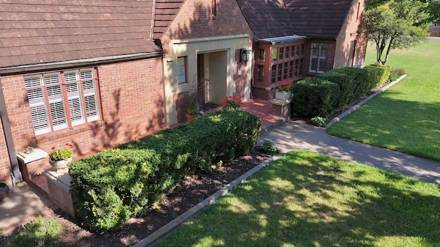 entrance to property featuring a lawn