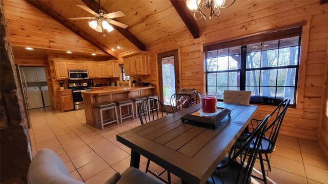 dining area with light tile patterned floors, wooden ceiling, wooden walls, beamed ceiling, and washing machine and clothes dryer