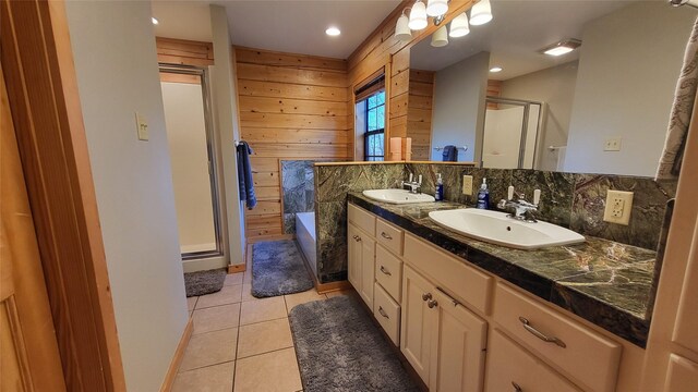 full bathroom featuring wooden walls, tile patterned floors, a sink, and a shower stall