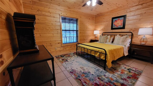 tiled bedroom with wood ceiling, wood walls, and a ceiling fan