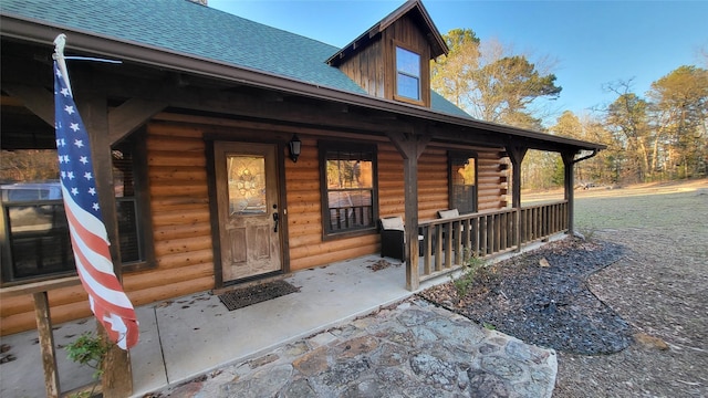 property entrance with a porch and roof with shingles