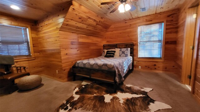 carpeted bedroom featuring a ceiling fan, wooden ceiling, and wooden walls