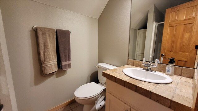 bathroom featuring toilet, tile patterned floors, an enclosed shower, vaulted ceiling, and vanity