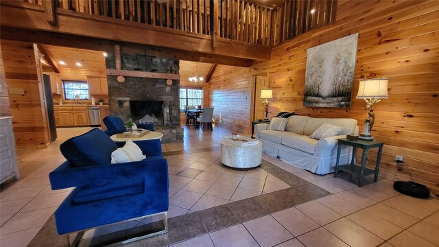 living room with a high ceiling, light tile patterned flooring, a fireplace, and wooden walls