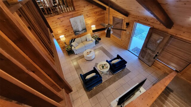 unfurnished living room featuring vaulted ceiling with beams, tile patterned floors, and wooden walls