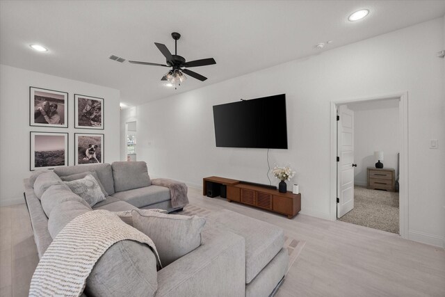 living room featuring light colored carpet and ceiling fan