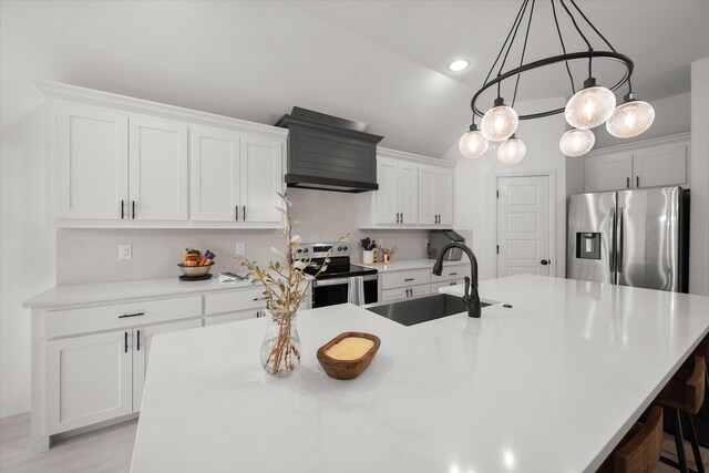 kitchen with white cabinetry, a kitchen island with sink, stainless steel appliances, decorative backsplash, and sink